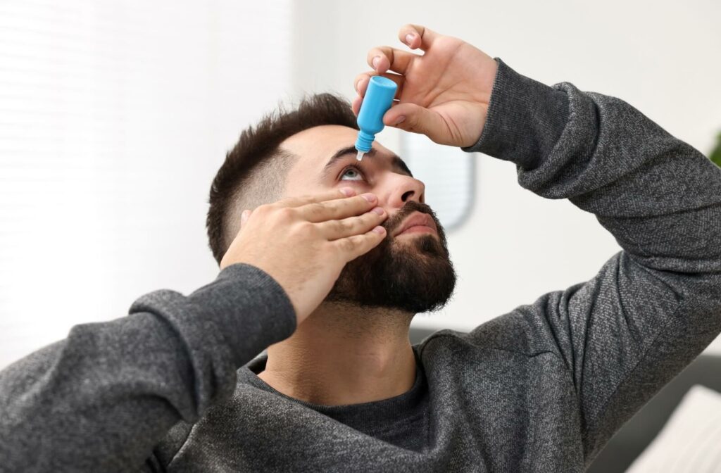 A man places eye drops in his eye to get relief from dry eye symptoms.