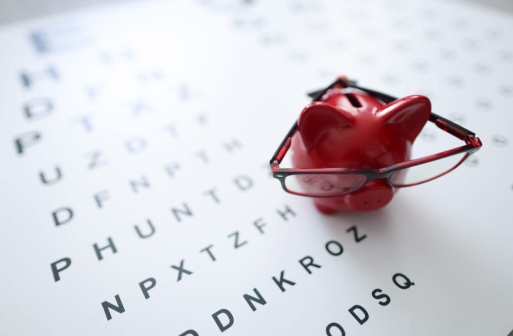 A piggy bank wearing glasses sits on top of an eye chart.