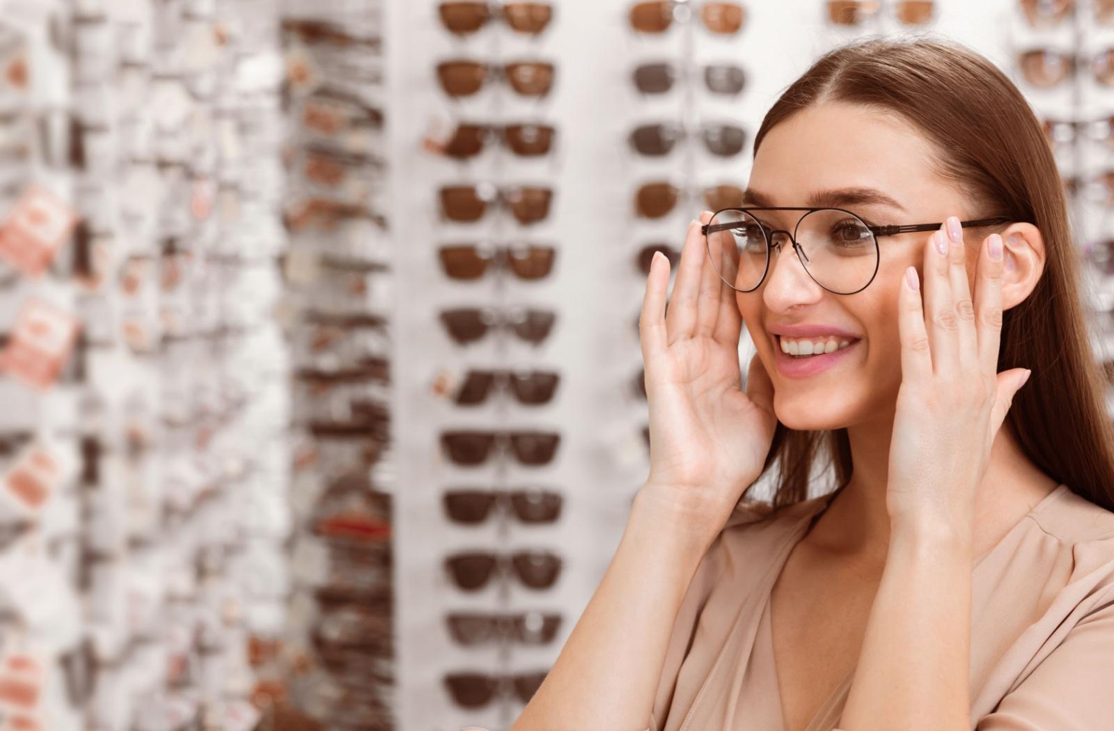 A person trying on thin framed glasses while at the optometrist